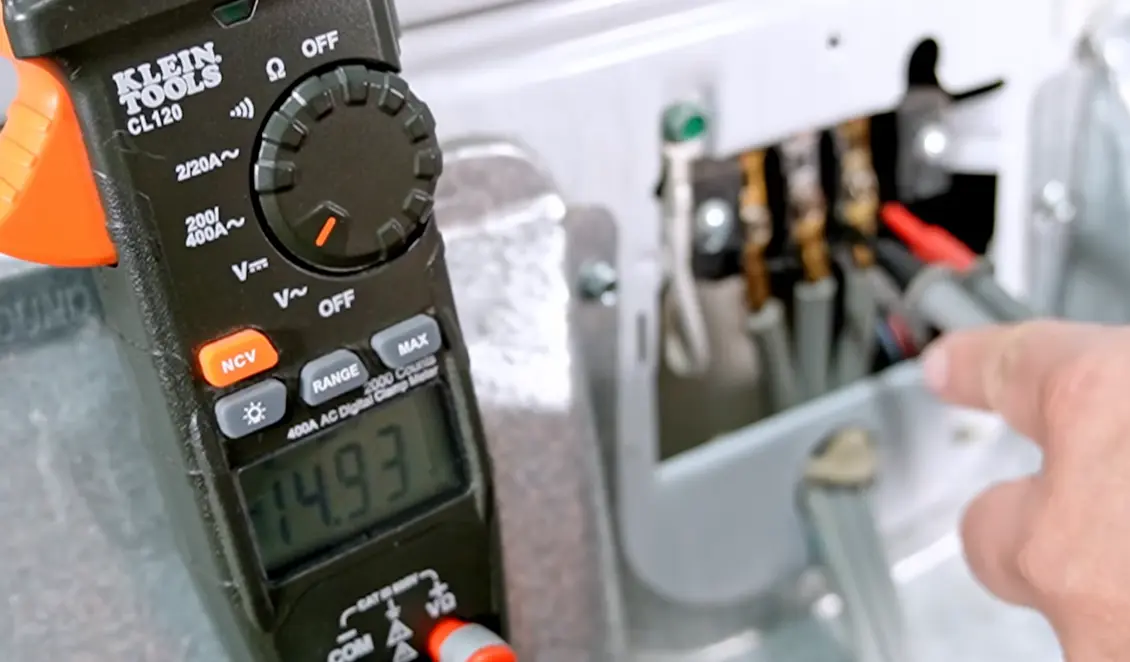 Cedar Rapids dryer repair technician checking voltage with ohm meter during diagnosis
